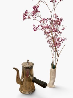 flowers in a vase next to a teapot and a tea kettle on a white surface