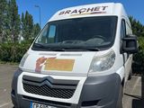 une camionnette blanche garée sur un parking avec des arbres en arrière-plan