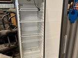 a refrigerator that is sitting in a warehouse next to a pile of junk
