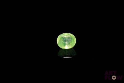 un gros plan d'une boule verte lumineuse posée sur une surface noire