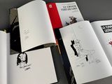 a lot of books that are open on a table