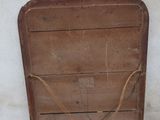 an old wooden sled leaning against a white wall