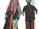 two dolls of a man and a woman standing next to each other