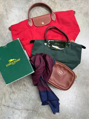 un sac à main, un livre, une écharpe et une paire de lunettes par terre