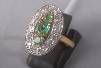 an image of a close up of a ring with emeralds and diamonds