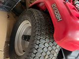 a red lawn mower sitting on the ground next to a pile of boxes