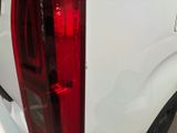 a white truck with a red tail light on the back of it