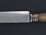 a knife with a wooden handle on a black surface