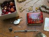 a box of jewelry on a table with a bunch of other items