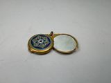a close up of a gold locke with a blue and white medallion on it