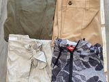three pairs of men ' s pants in a box on a wooden floor