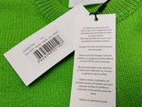 a close up of a green sweater with a tag on it