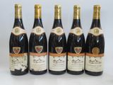 six bottles of wine are lined up in a row on a table