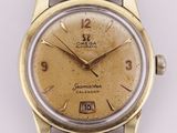 an image of a gold and black watch on a white surface