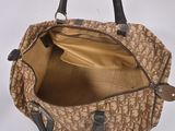 brown and black handbag hanging on a white wall with a white background