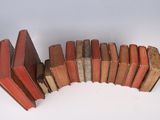 a stack of books sitting on a table next to a cup