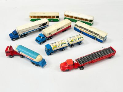 six petits bus et un semi-remorque posés sur un fond blanc