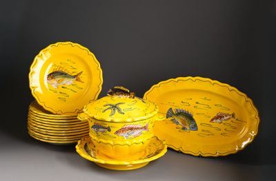plusieurs assiettes jaunes ornées de poissons, posées sur une table