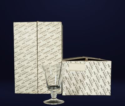 an empty glass sitting next to a box on top of a table