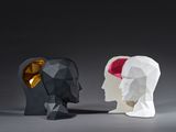 two paper sculptures of a man and a woman facing each other