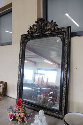 a large mirror sitting on a table next to a vase of flowers