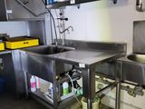 a stainless steel sink and a metal counter in a commercial kitchen