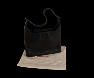 the black purse is sitting on top of a white bag
