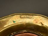 a close up view of a brass vase with a brown lid