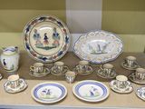 de nombreuses assiettes et tasses posées sur une étagère dans une pièce