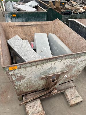 beaucoup de déchets dans une benne à ordures posée au sol