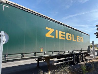 un gros camion vert qui roule sur la route