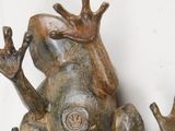 a statue of a frog that is sitting on a table