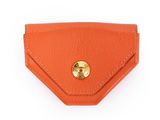 un étui-portefeuille en cuir orange orné d'un bouton doré sur le devant