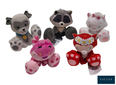 Trois peluches sont assises les unes à côté des autres sur une surface blanche