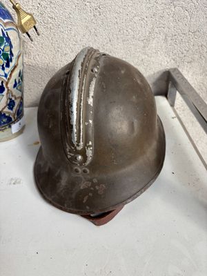 un casque métallique posé sur un plateau à côté d'un vase