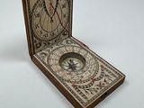 a small wooden box with a compass inside of it