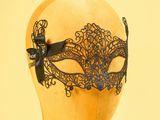 un masque en dentelle noire sur une tête de mannequin