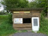 a small wooden building with a sign on it
