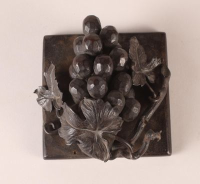 a metal object with a bunch of grapes on it
