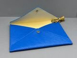 un gros plan sur une enveloppe bleue ornée d'une fermeture à glissière dorée