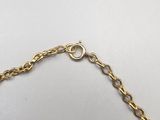 a close up of a gold chain bracelet on a white surface