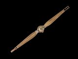 une image représentant une montre en or sur fond noir