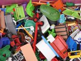 a large pile of toy cars and trucks in a purple box