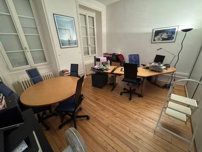 une pièce avec une table, des chaises et un ordinateur portable posé dessus