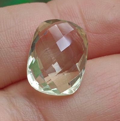 une personne tenant dans sa main un gros cristal jaune
