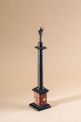 une statue représentant un homme debout au sommet d'un piédestal