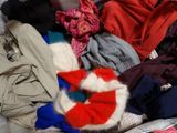 a pile of clothes that is sitting on a bed