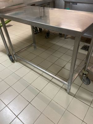 a stainless steel table in the middle of a kitchen
