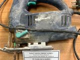 une photo d'une scie sauteuse filaire posée sur une table en bois