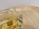 a small square glass bottle on a wooden table